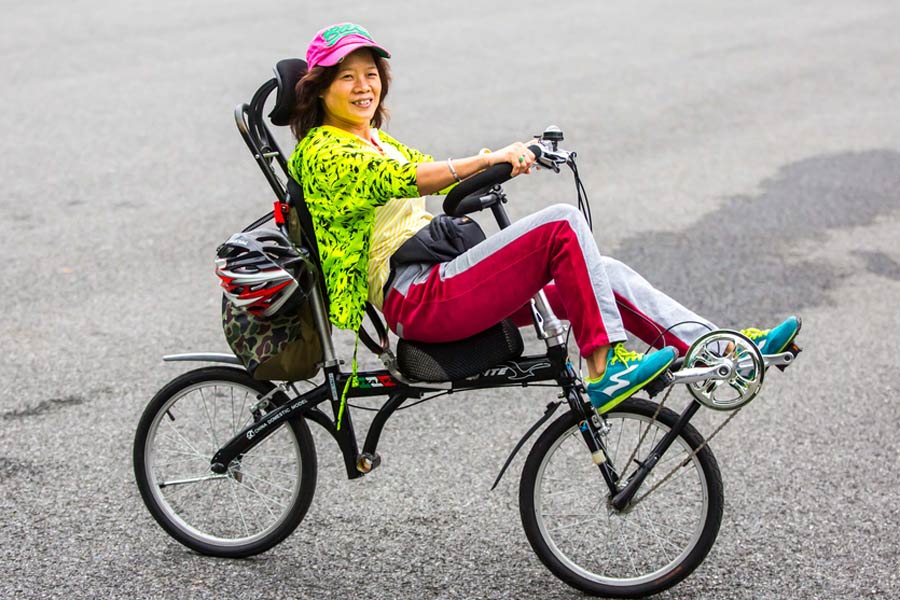 Cyclists sit back as they pedal through Guangzhou