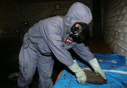 An expert from the Office of the Ministry of Foreign Affairs for Chemical Weapons Abandoned by Japan in China, Huang Shunxiang, digs out a bomb at an excavation site of World War Two chemical weapons abandoned by Japan, in Ning'an, China's Heilongjiang province, July 5, 2006. The two countries disagree on the scale of corroding weapons left behind by Japan's army after the World War, with China saying there are 2 million shells to be dealt with, while Japan puts the figure in the hundreds of thousands. REUTERS