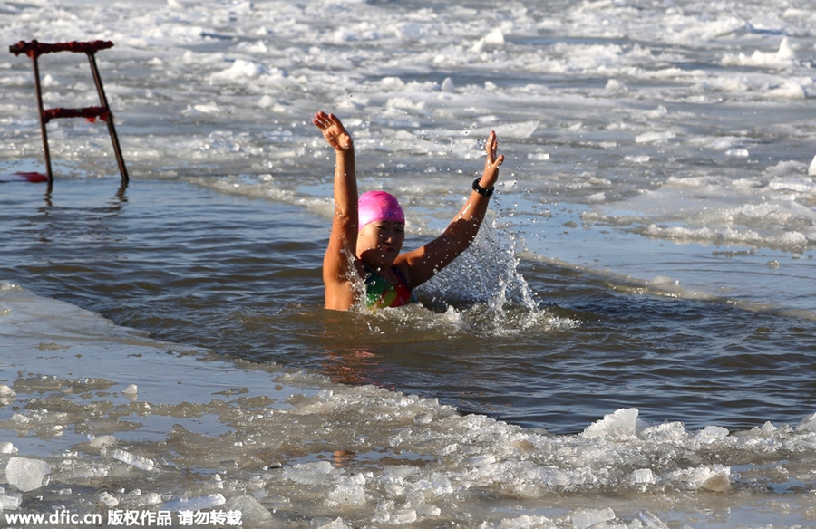 Swimmers battle against the cold in ice-covered river