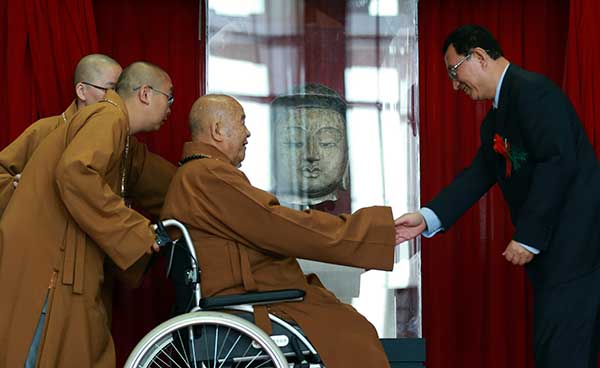 Hundreds cheer abbot's efforts to return Buddha head