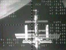 The International Space Station is visible from a black and white television camera on the Soyuz as the two crafts prepare to dock Saturday, April 16, 2005. The new ISS crew, Russian commander Sergei Krikalev and U.S. astronaut John Phillips are aboard the Soyuz capsule. European Space Agency astronaut Roberto Vittori is traveling with Kriklalev and Phillips and will return to Earth April 25th with the outgoing ISS crew. The Earth is visible in the top left side of the frame.(AP 