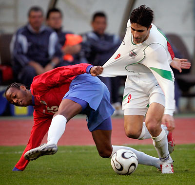 Costa Rica's Junior Diaz Campbell (L) fouls on Iran's Vahid Hashemian (9) during an international friendly at Tehran's Azadi stadium March 1, 2006. Iran defeated Costa Rica 3-2.[Reuters]