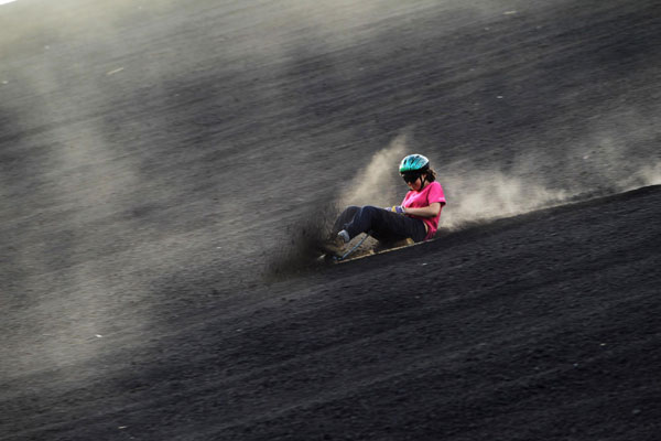 Tourists surf Cerro Negro volcano in Nicaragua