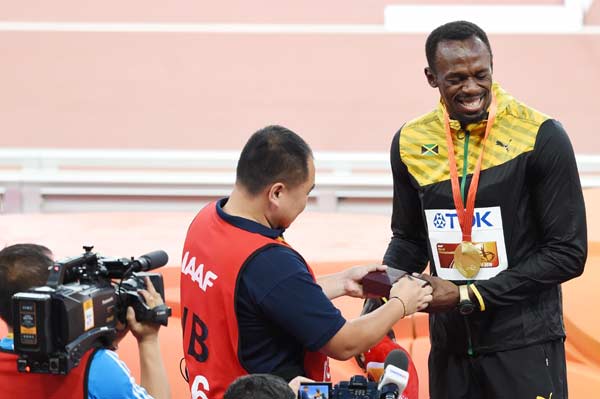 Bolt receives lucky 'sorry' bracelet from fallen cameraman