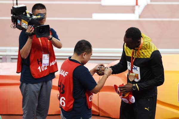 Bolt receives lucky 'sorry' bracelet from fallen cameraman