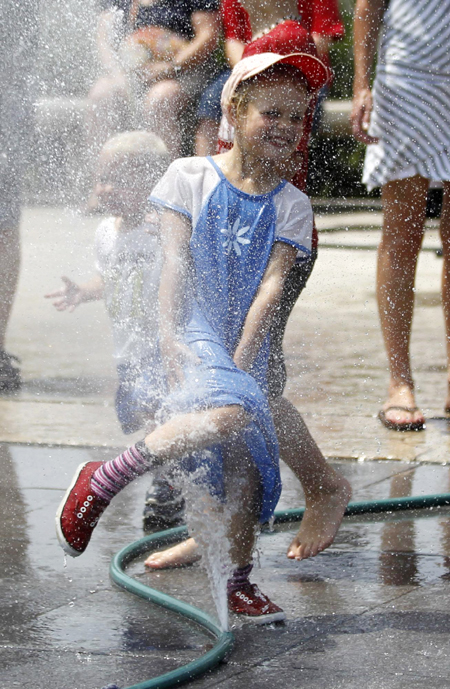 Children play with sprays of water in Washington